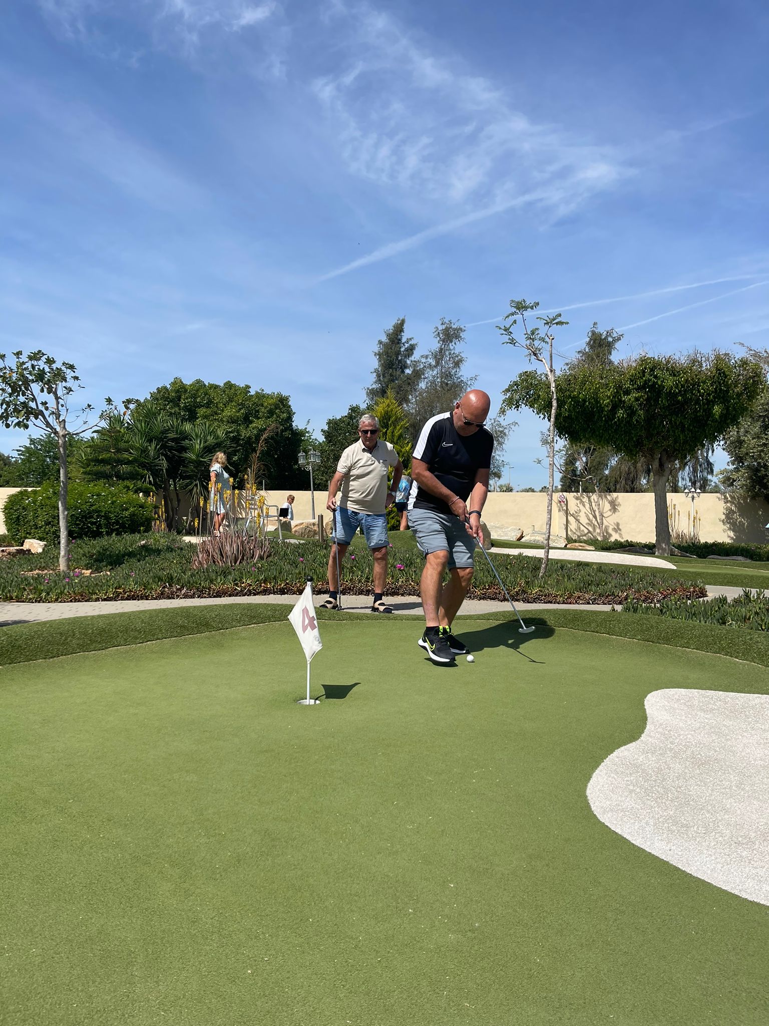 A golfer putting at hole 4 with a bunker on the adventure golf course
