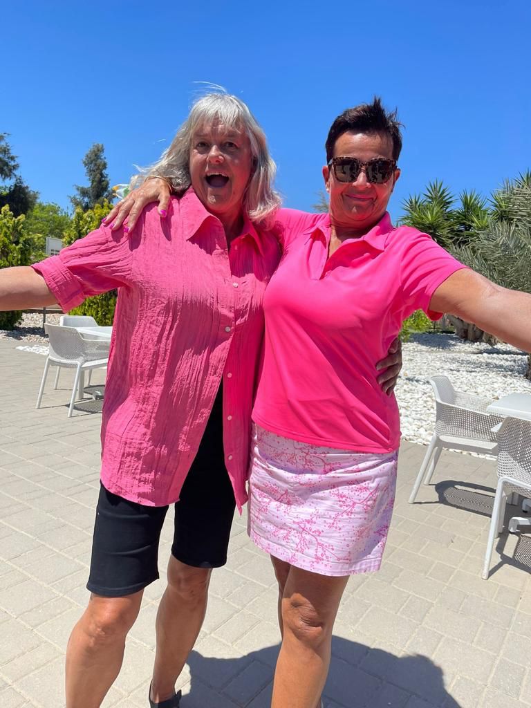 Two friends laughing on the sunny terrace at Golf Delux
