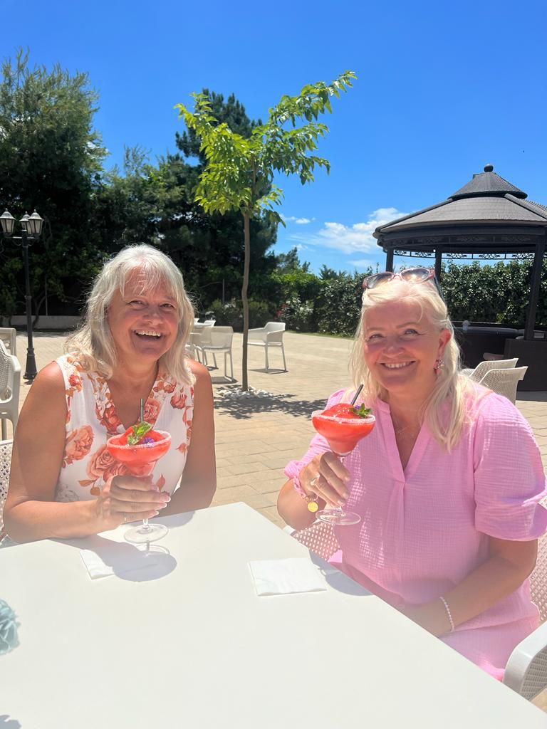 Guests enjoying cocktails at a table on the Golf Delux terrace